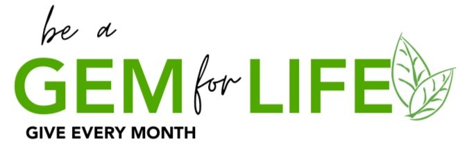 Text graphic with phrase "be a GEM for LIFE" in green and black, with "GEM" and "LIFE" emphasized. Includes a leafy graphic. Below reads "GIVE EVERY MONTH."
